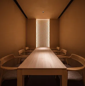 Warm and inviting dining space with a long wooden table and four chairs, surrounded by comfortable seating
