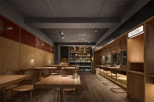 Warm and inviting bar interior with wooden floors and tables, chairs, and bottles on display
