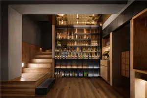 A bar interior with wooden floors and walls, featuring a collection of bottles on shelves in an organized and visually appealing display