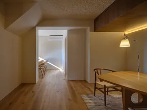 A warm and inviting dining space with a wooden table surrounded by chairs and a nearby couch, creating a cozy atmosphere