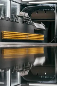 Industrial workspace with a black countertop featuring yellow stripes and yellow objects, suggesting a functional and organized environment