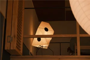 A dimly lit room with a chair in front of a window, natural light illuminating the space, and two lights on the left and right sides