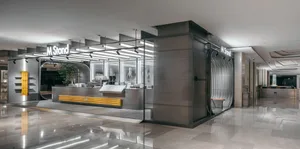 A modern restaurant interior with a counter and chairs, featuring clean lines, minimalistic design, and well-lit atmosphere