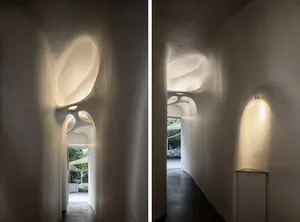 A well-lit interior space with white walls, a hallway, and seating areas for visitors, ideal for showcasing artwork or artifacts