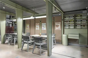 綠色調的舒適餐廳用餐區，柔和燈光，環繞中央餐桌的舒適座椅