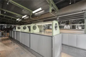 工業風廚房配雙水槽、烤箱與冰箱，周圍環繞各式廚具與器具