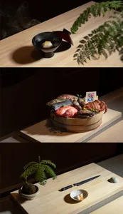 餐廳區域內的餐桌，擺放著一碗魚、一盤海鮮與盆栽