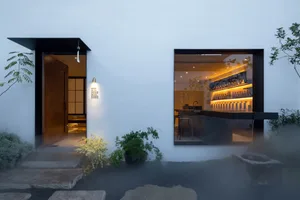 Cozy cafe interior with a counter, chairs, and white walls, creating a clean and modern atmosphere