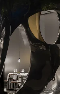 現代餐桌與椅子的餐廳區域，周圍環繞黑白牆面，桌上擺放碗具與酒杯