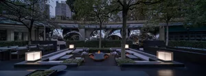 A patio area with chairs and dining tables arranged around a fire pit, creating a cozy and inviting atmosphere for gatherings and social events