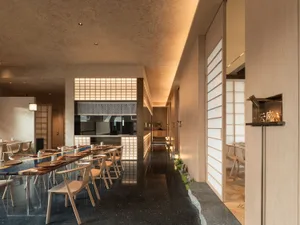 Warm and inviting restaurant interior with wooden floors, tables, and chairs, creating a comfortable dining atmosphere