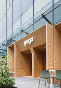 A modern restaurant with a wooden facade, featuring a comfortable and inviting atmosphere for patrons to enjoy their meals or drinks