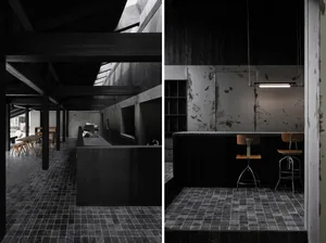Modern dining and kitchen space with wood and metal accents, dim lighting, and minimal decoration