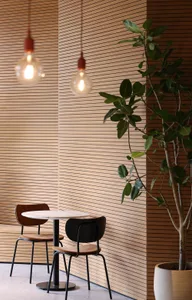 Cozy dining area with wooden paneling, two chairs, and a small table, lit by three lights