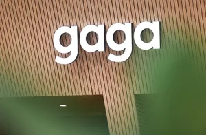 A modern building with a wooden exterior, featuring a large sign reading Gaga, in a contemporary architectural style