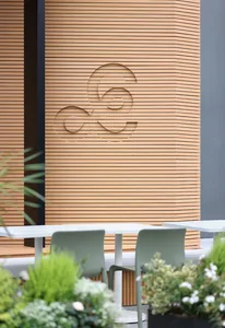 Warm and inviting dining space with wooden walls, a table, and two chairs, featuring a logo on the wall