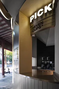 輕鬆咖啡店內部，設有吧台、冰箱與多個杯子置於桌面，顧客在溫馨氛圍中享受時光