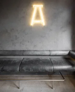 A calm and inviting living area with a sleek leather sofa against a wall, surrounded by empty space