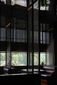 現代餐廳黑色牆面用餐區，盆栽與極簡裝飾