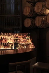 A well-stocked bar with a variety of liquor bottles displayed on a counter, creating a cozy and inviting atmosphere for socializing