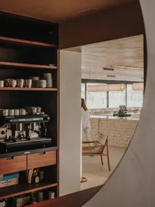 Cozy cafe interior with wooden counters, chairs, and multiple cups, creating a welcoming atmosphere for coffee and beverage service