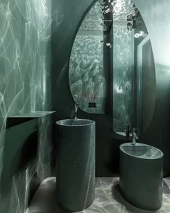 Bathroom with two concrete sinks under a mirror in a dimly lit space with a modern and minimalist aesthetic