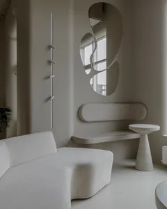 Empty modern living room with two couches, a chair, and concrete walls, giving a calm and inviting atmosphere