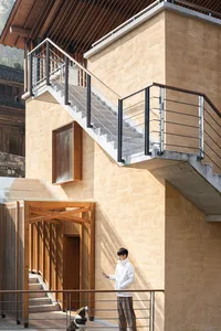 A rustic building with a wooden staircase, two people, and a traditional design