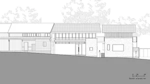 Two modern houses on a hillside with red and gray roofs, large windows, and natural light, surrounded by trees
