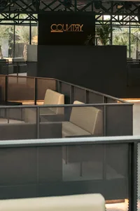 Comfortable indoor space with multiple couches and chairs arranged around a central point, creating a warm and inviting atmosphere for socializing and relaxation