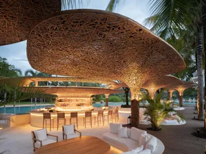 A well-lit living space with a wooden dining table and chairs, a bar, and a warm atmosphere