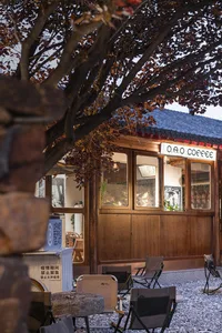 Warm and inviting Asian restaurant with wooden walls, a red roof, and a dining area with chairs and potted plants