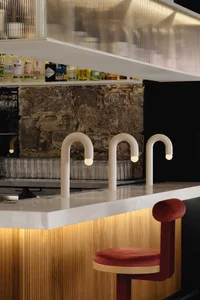 Modern kitchen with white faucets, wine glasses, and scattered cups on a countertop