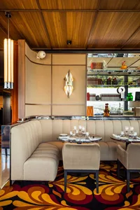 Sophisticated dining space with multiple tables, chairs, and decorative items, set in a warm and inviting atmosphere