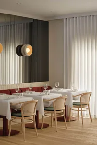 A sophisticated dining space with a long wooden table and multiple chairs, set with wine glasses, plates, and cutlery, creating an inviting atmosphere for guests