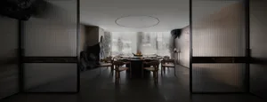A dining area with a round table set with wine glasses, bowls, cups, utensils, and apples, in a sophisticated and inviting atmosphere