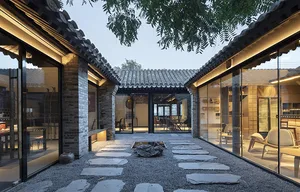 A serene Asian-style house with a courtyard area featuring a rock garden, stone walls, and tiled roofs