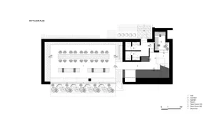 Large interior space with multiple dining tables and chairs, featuring a functional layout for gatherings and events