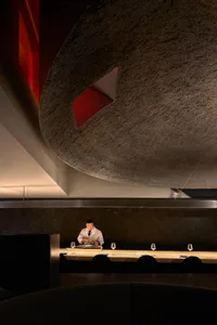 石牆優雅餐廳空間，木質家具與桌上的酒杯