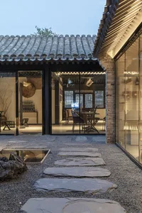 Cozy Asian-style living room with a dining table, chairs, TV, and artwork on the walls, conveying a sense of warmth and comfort
