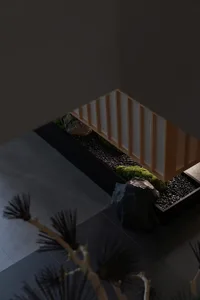 A serene indoor space with a rock garden in the corner, featuring several rocks and a calm atmosphere