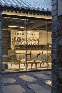 Modern showroom with glass walls, various chairs, and dining tables, featuring a stylish and contemporary atmosphere