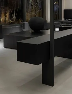 Modern room with a black table, sphere, and benches, featuring a chair and a large window