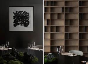 A warm and inviting space with a dining table setup and a wood-paneled bookshelf, featuring wine glasses, bowls, cups, and a collection of books