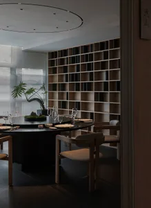 Sophisticated dining area with a round table, chairs, wine glasses, and potted plants, set in a restaurant