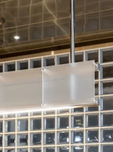 A well-lit kitchen with glass panels on a hanging light fixture, clean and inviting atmosphere