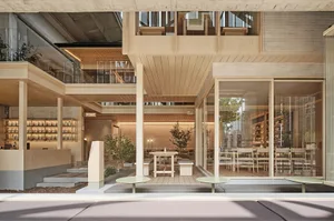Open dining area with modern design, multiple tables, chairs, and potted plants, inviting atmosphere