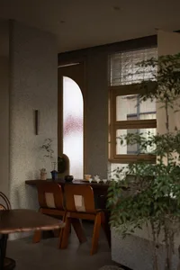 Cozy dining space with a wooden dining table and chairs, natural light from a window, and a warm atmosphere