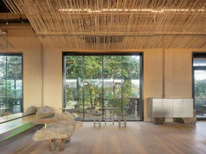 A restaurant interior with wooden walls, tables, chairs, and benches, creating a warm and inviting atmosphere