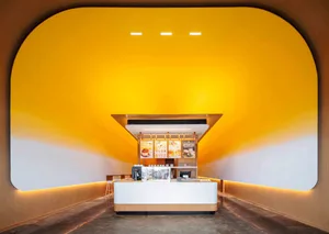 A restaurant dining area with a counter and chairs, featuring a warm and inviting atmosphere